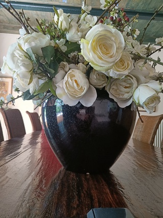 Zwarte vaas met witte zijden bloemen