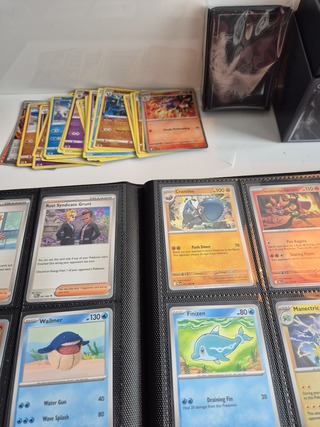 Collectie Pokémon kaarten in vezamelmap, o.a. Prismatic Evolution & Pi